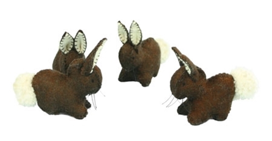Drie donkerbruine konijnen in wolvilt met witte staart en binnenkant van de oren.