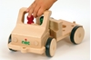 Camion en bois, modèle de base court, pour placer différents outils. Une main placée sur le guidon conduit le camion.