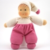De knuffelpop in roze en witte badstof staat recht.