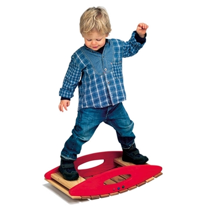Un enfant blond, habillé tout de bleu, se tient en équilibre sur une balançoire en bois d'aulne massif couleur rouge et bois naturel.