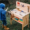 A child plays/works  with a solid wood kids workbench