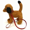 Petite laisse jouet en cuir rouge pour animal en peluche montée sur un chien en peluche brun.
