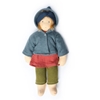 Nanchen doll Alva with blue eyes and reddish blonde hair held back by a blue wool headband, red dress, green knitted wool pants and a blue-grey hooded wool fleece jacket.