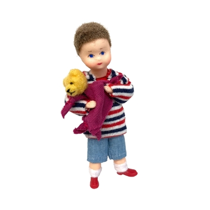 Poupée pour maison de poupée, petit garçon avec culotte courte bleu clair et sweat-shirt rayé rouge et bleu, portant un Nounours dans ses bras, ainsi qu'un chiffon mauve.